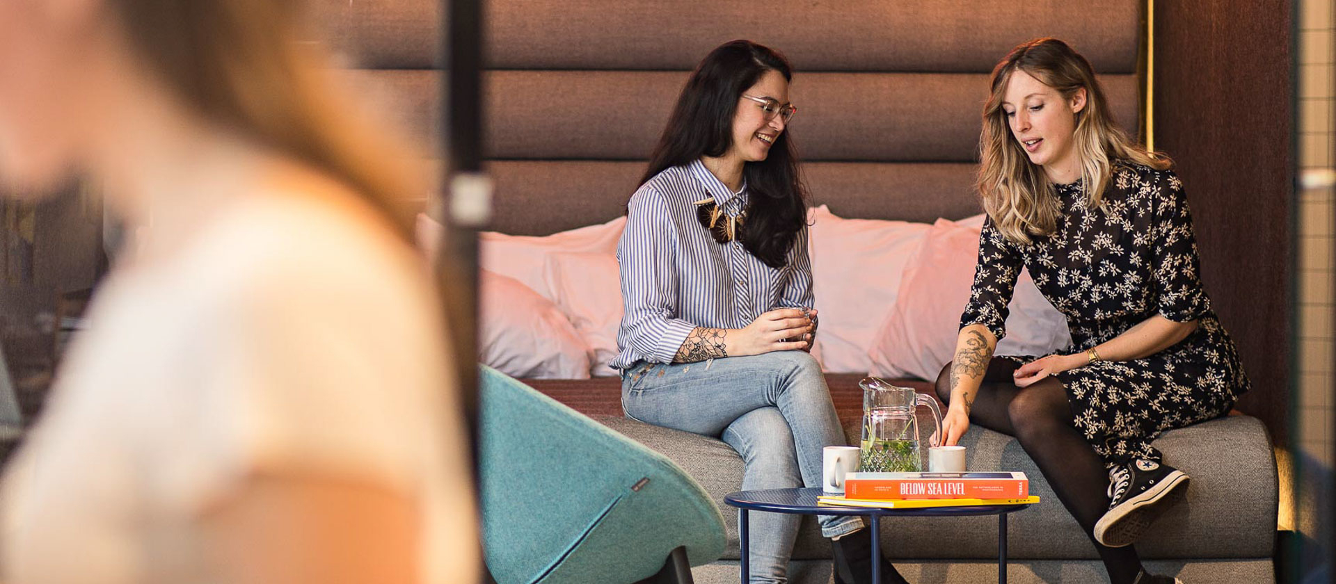 Two women catch up on the bed in the BedTalks meeting space at The Student Hotel Rotterdam