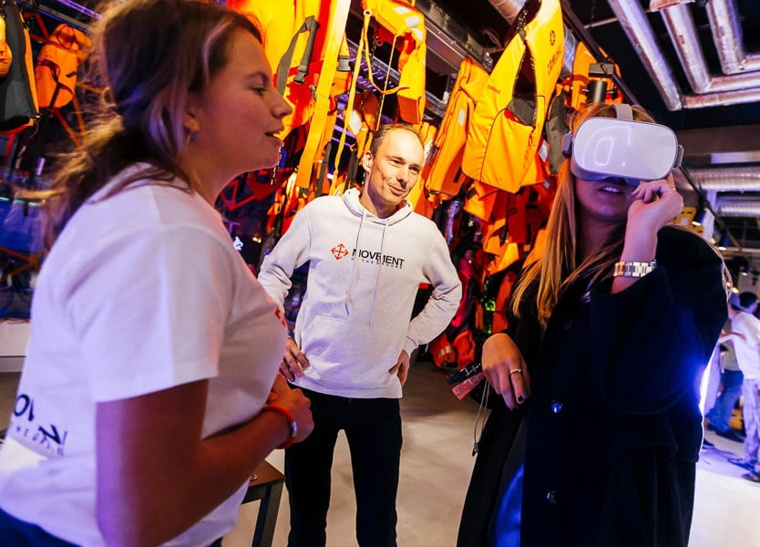 Woman tries VR goggles as two attendants look on at an event at The Student Hotel Rotterdam
